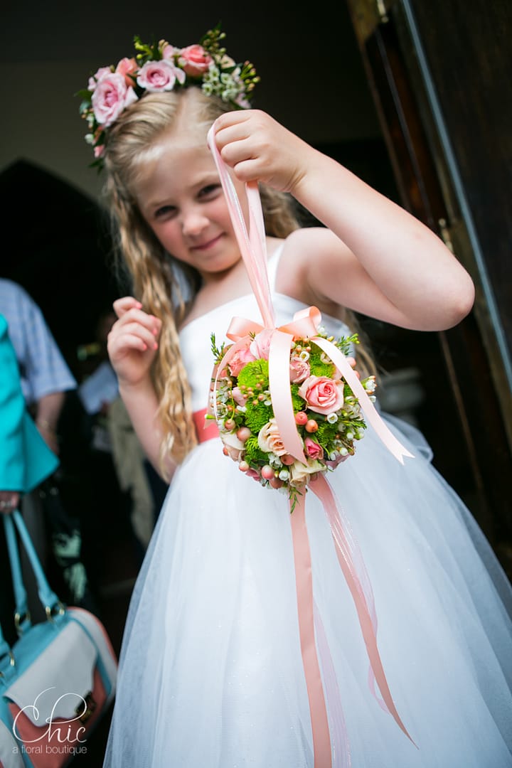 About flower girl, pomander ball, flower crown, peach flowers, pink flowers, green flowers, hypericum, roses, spray roses, waxflower, chrysanthemums, peach trailing ribbon, peach pink and green flowers, long island wedding flowers, long island weddings, long island wedding florist, st dominics oyster bay, chelsea mansion wedding